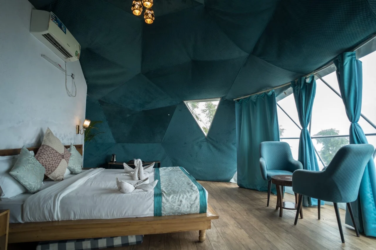 Spacious dome interior with bed and seating beside large windows